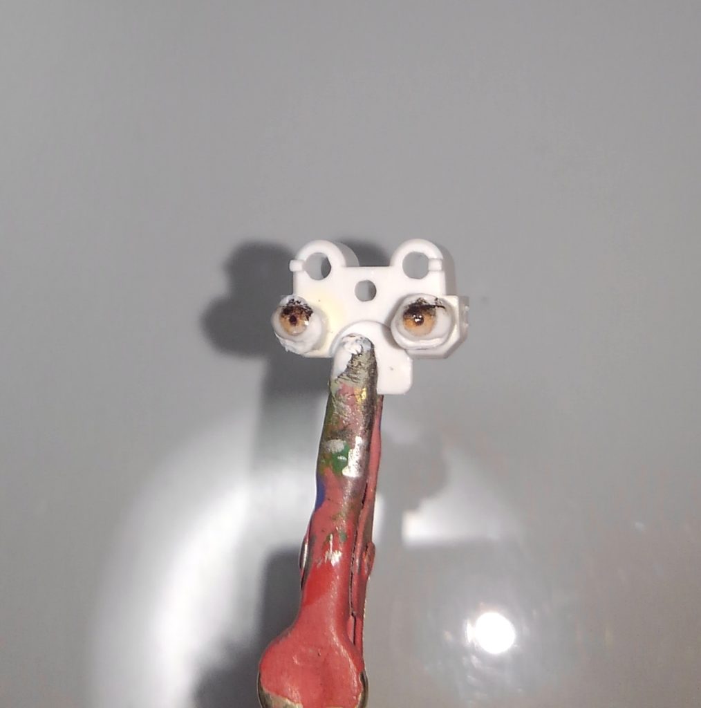 目パーツです。上の方が汚いですが見えないwので気にしないで下さい。基本上の方は暗く下の方は明るく。下の方は塗ったか塗らないくらいの薄さがよいと思います。瞳孔は液体の表面張力を利用します。少し緩めに溶いた黒をわずかに一滴、目の真ん中に落とします。表面張力でまん丸になるはずです。そのまま乾燥させるとほぼ円形にできると思います。失敗したらw乾く前に拭いて再チャレンジ。最後にラッカークリアを軽く筆塗りして目パーツ完成です。