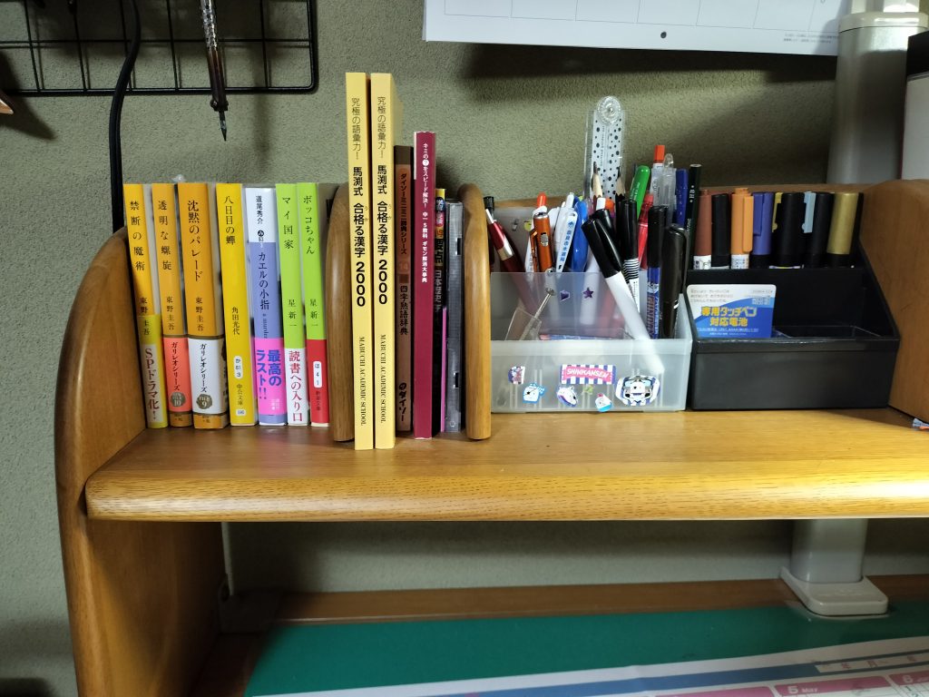 乱雑な筆立てですが何卒お許しくだせぇ何故か同じ辞書が2冊ありますミステリー小説が好きなので東野圭吾や道尾秀介の本があります