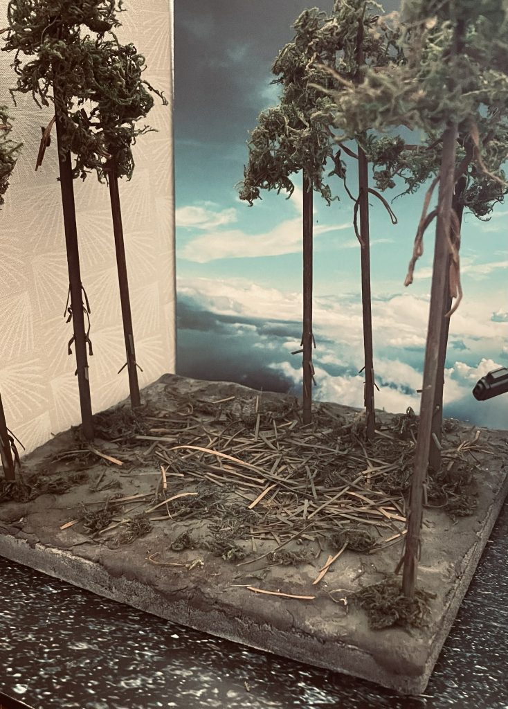 ジオラマベースとなります。幹は木の棒にレッドブラウンで着色したものを用いています。枝はビニタイ(針金入りのひも)を幹に通しています。葉はダイソーのフェイクモスを木工用ボンドで根気よく接着したものです。地面にはダークグリーンを吹いて質感を高める工夫をしています。