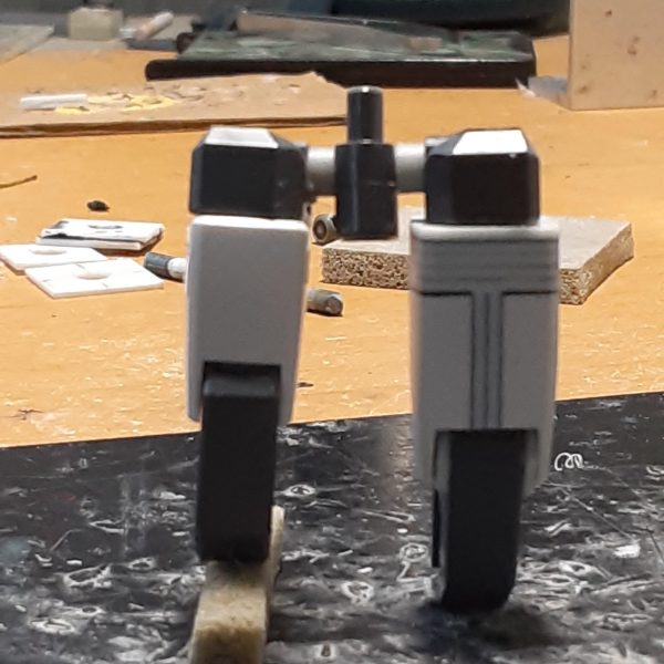 脚部の太さや長さのバランスを調整した0ガンダムの下半身。膝の位置関係から、左右の腿の長さが変わったのがよくわかると思います。 キットのままだと腿は細くて短いので、左右に2mm、上下に5mm延長。股関節の付き位置を1.5mm上げて、ロール部の分割ラインが目立たないように加工。結果的にもともと長い脚が1mm強長くなりましたが、これは腿やアンクルガードの横幅を増やした分、相対的に上下に短く見えてしまうのを防ぐためでもあります。 ↑の「1mm強」の内訳：足首関節で-3ｍｍ、アンクルガード用のジョイントで+1.2ｍｍ、腿の延長で+5ｍｍ、股関節を上げて-1.5ｍｍ 膝関節上部に付いている白い物は、腿の幅増しで空いた分の隙間を埋めるためのプラ板。こういう平面上に薄い板が一段被さったようなデザインが好きなもので。膝を曲げる時にふくらはぎに干渉しないギリギリのラインを狙った位置に貼っています。（3枚目）