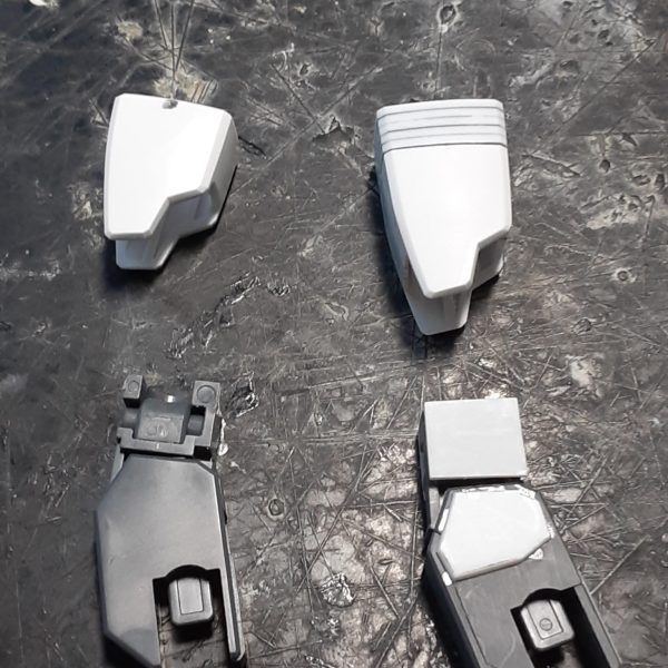 脚部の太さや長さのバランスを調整した0ガンダムの下半身。膝の位置関係から、左右の腿の長さが変わったのがよくわかると思います。 キットのままだと腿は細くて短いので、左右に2mm、上下に5mm延長。股関節の付き位置を1.5mm上げて、ロール部の分割ラインが目立たないように加工。結果的にもともと長い脚が1mm強長くなりましたが、これは腿やアンクルガードの横幅を増やした分、相対的に上下に短く見えてしまうのを防ぐためでもあります。 ↑の「1mm強」の内訳：足首関節で-3ｍｍ、アンクルガード用のジョイントで+1.2ｍｍ、腿の延長で+5ｍｍ、股関節を上げて-1.5ｍｍ 膝関節上部に付いている白い物は、腿の幅増しで空いた分の隙間を埋めるためのプラ板。こういう平面上に薄い板が一段被さったようなデザインが好きなもので。膝を曲げる時にふくらはぎに干渉しないギリギリのラインを狙った位置に貼っています。（2枚目）