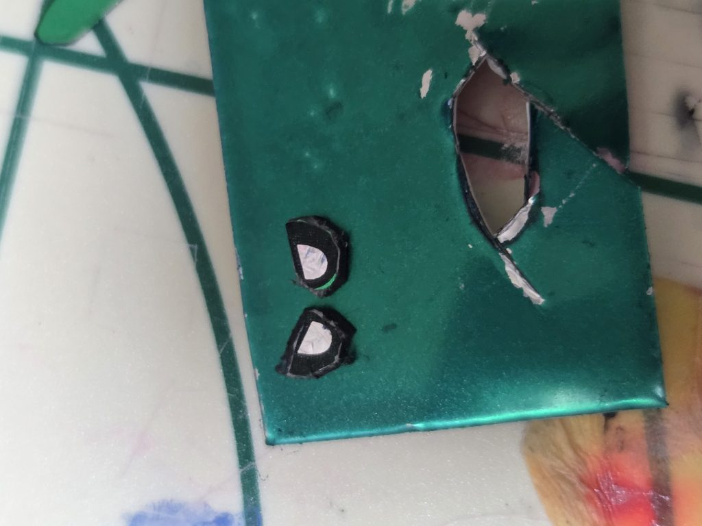 まずはメタルテープを目の形に切ってグリーンに塗装、さらに目のシールの瞳部分だけをマグネットテープに接着し、以前の魔殺駆のように可動させられると思ったのですが…