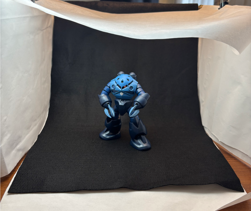 撮影ボックスはこんな感じです。側面には模造紙、背面と床には黒フェルト布を引っかけています。天井にクッキングシートを渡すことで、いい感じに光が拡散してくれます。