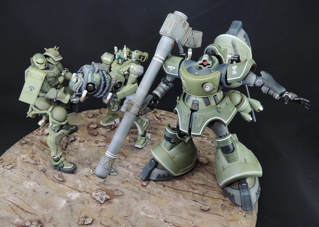 ■「自爆ザク」について 「自爆ザク」は、劇場先行版『機動戦士Gundam GQuuuuuuX -Beginning-』および、TVアニメ『機動戦士Gundam GQuuuuuuX』第8話「月に墜(堕)ちる」に登場しました。 ストーリーは、「一年戦争末期、地球連邦軍によるソロモン要塞落下作戦を阻止すべく、シャア率いるソドン艦隊が出撃。目的は月面都市グラナダの防衛。」であり、作戦内容は、「4隊に分かれてインプロージョン地点に送り込み、そこで無人のザクを自爆させて主動力炉を破砕・誘爆させ、正面東側のサミットの破断によりグラナダに墜ちるソロモンの軌道を変える」というものでした。 劇中では、ザクやゲルググが2機一組で自爆ザクを抱え、強襲揚陸艦ソドンから運搬する様子が描かれました。