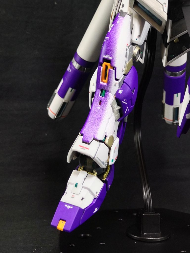 以下は、会話形式で当時の心境をだらだらと書いていますので読み飛ばしても大丈夫です😄。当日は、早朝５時前から塗装しておりました。7時頃「塗装も終わったしメシ(朝マック)でも食って帰るか」「あれ？、塗り漏れがあるな、最後、吹いとくか」「白のスプレーは、お、コレか」プシュー…「[壁]∀･)ん?、んGaWkまuがPー🤯、なんじゃこりゃあ～‼️😱」「パ、パープル❗️、え⁉️フタはたしかに白、パープル⁉️」「や、やってもた～、フタ付け間違えてた～⁉️」「ど、どうする、とりあえずウェッティで拭く、アカンアカン❗️、どうする⁉️」しばらく( ゜o゜)ボー「塗装を落としてやり直すか❓️、上から白吹いてみるか❓️…🤔もう１度部分塗装とマスキングするのめんどくさいしとりあえず上から白吹くか、なんとかなるか❓️」10数分後「表面、乾いたしいけるか❓️」プシュー「やっぱりアカンかった❗️、パープルが下から浮かび上がってきた、もう少し重ねて吹いたらいけるか❓️、う～ん、たぶん無理やな、厚塗りになりそうやしな…、う～ん、とりあえず一旦乾燥させてから考えるか」「とりあえず、腹も減ったし朝メシ行こかなぁ💨」朝マックを食べながら「う～ん、どうするかなぁ❓️、全部パープルに塗ってオリカラにするか❓️、でもスネだけ塗ってもバランス悪そうだしな❓️、膝まで塗ればアシンメトリーでバランスが取れるか🙄……、うん、なんかいけそうな気がする」ネットでオリカラのνガンダムを検索「流石にアシンメトリーみたいのはないなぁ～、九龍版、違う！」「あ、この人スゲーな、RGのファンネルのディテールわざわざ消して、Ver.kaみたいにグラデにしてる…、グラデ…グラデ…、グラデーション🤯、お、グラデいけそう🤔」「失敗してもそのまま塗っちゃえば良いし、ここは実験的にチャレンジだな‼️」で、チャレンジした結果がコレです。