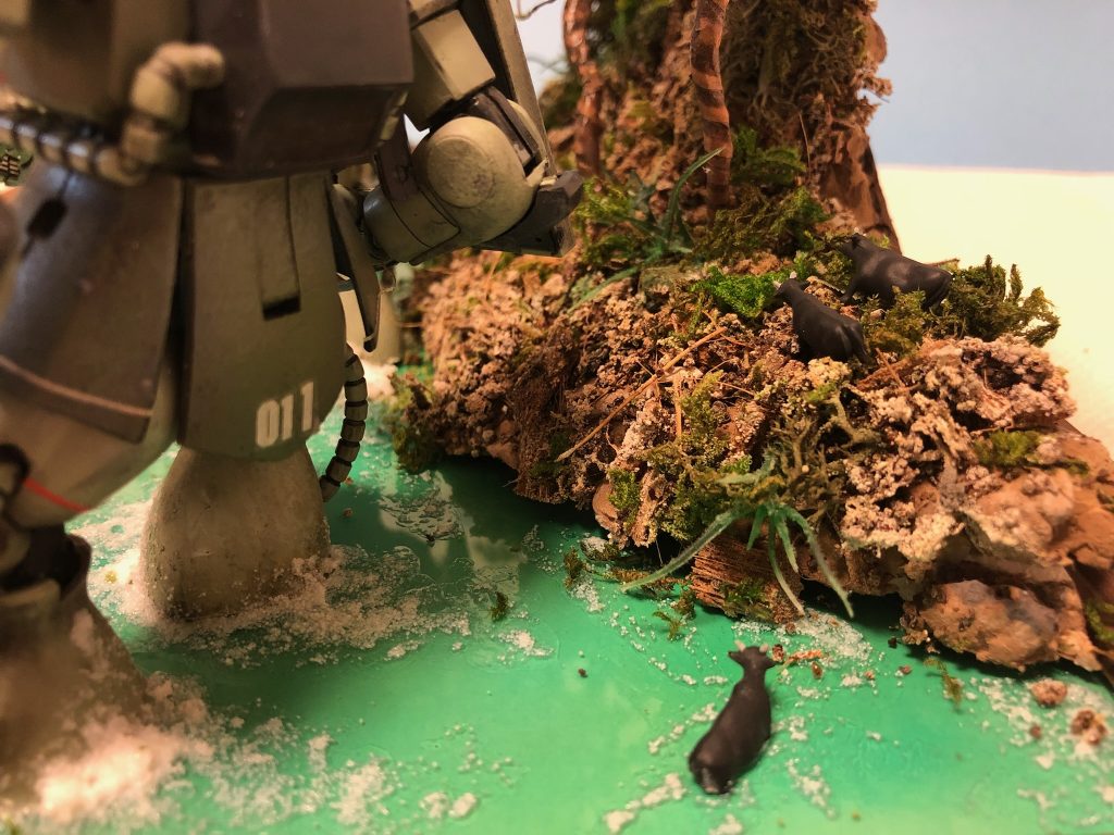 ザクの後ろを悠々と渡る水牛。トミーテックです。ザクの足はカットしています。