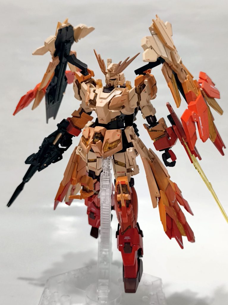 筆塗環境しかない中でグラデーション感をどう表現するかに苦労しました。結果としては写真のように、中心から末端へ、パーツ単位で徐々に色を変えながら塗り分けをしました。あまりガンプラに使うような色味ではない(しいて言うならガンダムWのヘビーアームズに近いか?)ので、組上げるまでは不安しかありませんでしたが、出来上がるとしっくりくるカラーバランスになりました。プロポーションについては、脚や腰の延長は行っていません。代わりに、手足をシャープに、上半身にボリューム感を持たせるように、以下の入れ替えをしています。・腕部のビームトンファーを、腿に。・踝のパーツを盾に(後述)・肩アーマーの90度回転:肩部へのアームドアーマー搭載のため。・腰のフロントカバーについていたパーツを、胸部に。・膝にスパイクを追加。盾のパーツを流用しています。今回素材にしているのは、ガンダムベース限定のユニコーンガンダムペインティングモデルです。本体の改造はほとんどミキシングはせず、このキットの中での部品入れ替えにて実施しています。