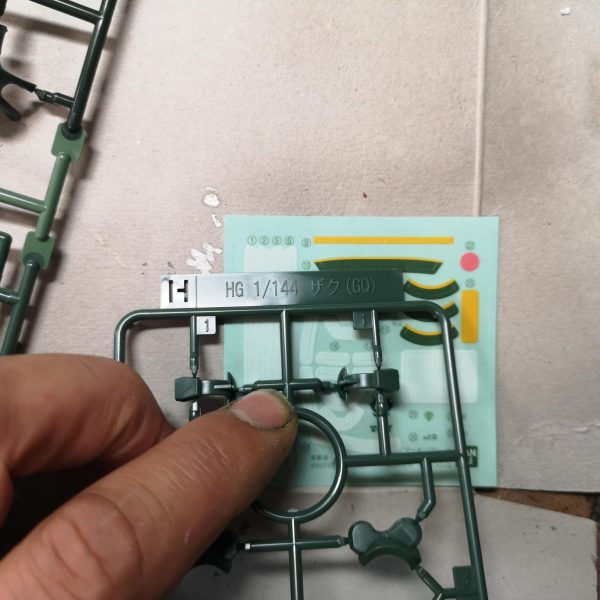 以前、GQザクの塗分けライン同塗分ける？という投稿に付属のシールでマスキングすれば？などと発言したので、責任をもって検証ししました。結果、普通にマスキングテープを細切りにした方がラクだな。との結論に至りました。途中、シールをトレースしてマステを切ったら？とも思ったのですが、曲面がきれいにカットできませんでした。成形色は緑が3種類。シールにあるのはおそらく中間の色。塗分けはラインが入りそうな所に白or黄色を塗っておく、肩のグリーンも。細切り（今回は１ｍｍ）のマステを貼っていく。曲線は自分の直感を信じて・・・スパイクアーマーは１か所一体成型になっているので、一旦切り離す。裏に肉抜きがあるので、そこをガイドに１㎜プラ棒で軸を作る。微妙に角度がついているので最終接着時に注意。マスキングが円形になりますが、黄色いラインの小径ｒが約8ｍｍ、ダイソーのサークルカッターで切れました（メモリが当てにならないので、手持ちのスケールで合わせた方が良い）。ラインの太さのお好みで大径を決めればよいかと思います。肩と腕の黄色いラインは一段下がっているので、最後あとから塗って、はみ出した部分をふき取るか、２段階にマスキングすればどうにかなりそうです。あとはマーキング類ですが、背中の２か所文字らしきものは、なんて書いてあるか解らないので、それっぽいヤツを貼ればヨシっ！！ジオンマークは若干サイズが違いますがガンダムデカールのジオンMS用③が赤白黄灰色の４色で大中小とあるのでそのへんかな？問題は盾の正面にある撃墜マーク？？っぽいのとジオンマークの下の「MAY VICTORY BE WITH US」の文字ですね最後に参考程度に手持ちのガンダムカラーのグリーン系（ラッカーと水性が混じっておりますが）左からラッカーのMSグリーン、MSディープグリーン、水性のﾌﾞﾗｽﾄｲﾝﾊﾟﾙｽｸﾞﾘｰﾝ、←たすブラックです。ん～どうでしょう、長くなりましたが参考になりますかね？（3枚目）