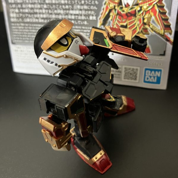 ガンダムマーカー塗装で、一通り完成しています。首と腰が細すぎなので、横にパーツを貼って幅増ししています。肩と胴体の接続部も細い印象でしたので、プラパイプで太く。首はかなり上を向けます。蛇腹状の武者の鎧を模しています。背骨状のパーツも付けています。足底の肉抜きにはG30ガンダムの足底を貼っています。軽装の頭部はSDWHのBUGの頭部を移植してます。元の武者頑駄無リスペクトで、金色の鉢金を付けているようにしています。兜との接続を検討中です。ネオジム埋め込むか？前垂れには隠れ砲を仕込んでます。瓢箪ファンネルも作成予定。パケ絵とは緑が足りませんが、ちょっと余計かなあと、塗ってません。背景にあるのは、やっと見つけたセリアの金屏風。もう1つ欲しい。（5枚目）