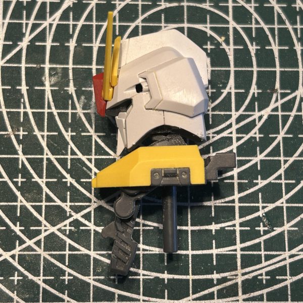 頭部ですがチョット面長だったので削って小顔化しつつ、追加で少しスジ彫りを入れました。〈追記〉側頭部と鶏冠に追加スジ彫りを入れてもう少しメカ感を出してみました。（2枚目）