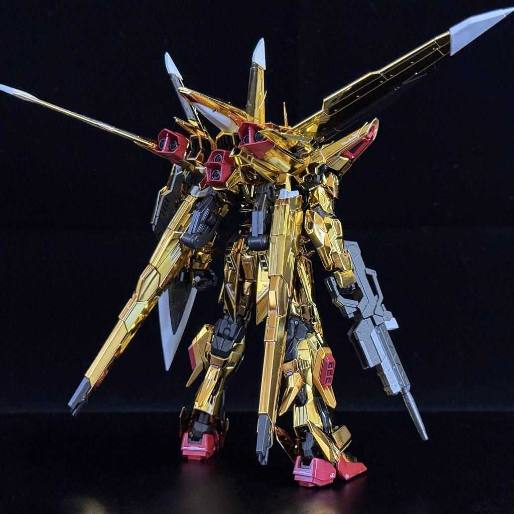 これはおそらく初めてのメッキパーツ制作であり、メッキパーツに水転写デカールを貼るのも初めてでした。正直に言って……本当に大変でした。メッキ部分のほとんどはゲート跡が隠れるようになっていますが、中にはかなり処理しにくい位置にあるものもあり、デザインナイフで処理していると、何度も自分の指まで削りそうになりました。また、外側に露出してしまうゲート跡を処理するために、事前に5〜6種類のゴールド塗料やマーカーを準備しましたが、どれも仕上がりがいまひとつで、結局は見なかったことにするしかありませんでした。全体的に見ると、外装がすべてメッキパーツのおかげで塗装作業はかなり減ったものの、実際にかかった時間は普通の機体を作るより長かったかもしれません。さらに撮影の段階がまたつらくて、片手に手袋をしていても指紋がどうしてもついてしまい、ポーズを調整しながら拭いて撮って……の繰り返しで、とにかく疲れました(zaku-kao3)