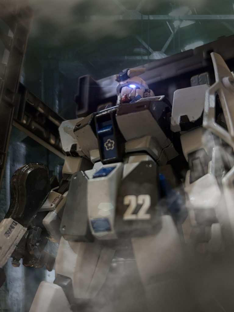 　言われて見上げると、火の入っている機体——その頭部には、デュアル・アイが輝いている——「”ガンダム”——！？」「我々はカーゴで脱出します。掩護、お願いできますね！？」　言って、”キッド”はカーゴに乗り込んだ。「わたしも、いっしょに……！」　チタが言う。一緒にコクピットに乗る、ということらしい。　チタの手を引き、地面を蹴る。ドックの重力は切られていた。　開け放たれたハッチから、コクピットに滑り込むと、機体データを手早く確認する。　なんということはない、今まで使ってきたジムの頭をガンダムのものに、ランドセルをキャバルリーと同型のものに挿げ替えたただけだ。多少、推進力は増したが、性能に大きな変化はない。機体バランスがちぐはぐな分、かえって扱いづらそうな印象を受ける。だが、なんだろうか——不思議な力を感じる気がする。（ガンダムには、魔力があるのかもしれない——。）　かつて、砂漠の戦場で、ヘントがそんなことを言っていた。　分かる気がする。　頭をデュアル・アイに替えた。それによって、この場にいる味方の期待や希望が、ここに集まってくる。ミヤギはその拡張された認知力で、確かに感じ取る。その感情の波が、機体に力を与える——これは、この機体は、紛れもなく”ガンダム”だ。『