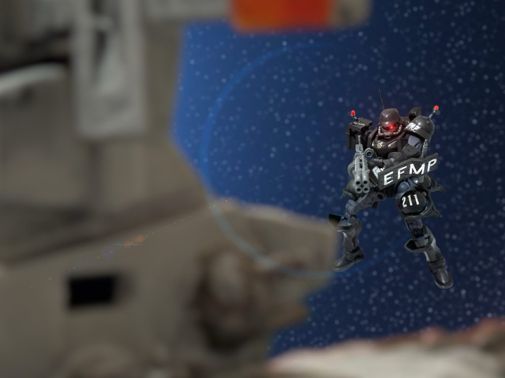 「反乱……！」　”サクラ”の護送に随伴していた、EFMP第１部隊第１班MS隊隊長バギー・ブッシュ中尉は、即座に反応した。分かっていた。逆に、いつ事を起こすのか、待っていたのだ。ブリッジごと吹き飛ばしてやろうかと思ったが、中には仲間がいる。スペースノイドどもには冷徹になれるが、仲間ごと敵を吹き飛ばすほど、非道ではない。　だが、警告はする。ビームマシンガンの銃口を向け、数発ビームをかすめて見せた後、オープン回線を飛ばす。「ブライトマン！抵抗すればブリッジごと吹き飛ばす！」非道ではない、と、自分に言い聞かせたが、いざとなればそうもなれる。中にいる兵も、そういう覚悟はあるはずだ。