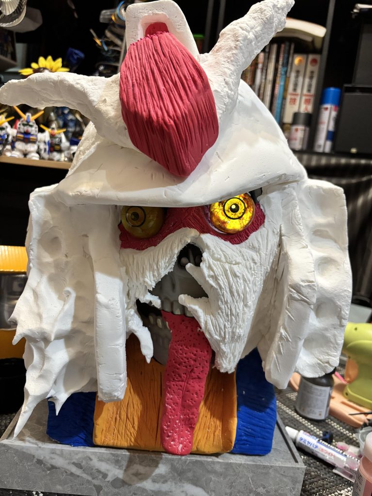 口のへの字を朽ちた感じの表現にしたのが気に入っています。舌は自分で作ってても気持ち悪いボツボツにしました。目はライトを仕込んで光ると黒目がでるようにしています。