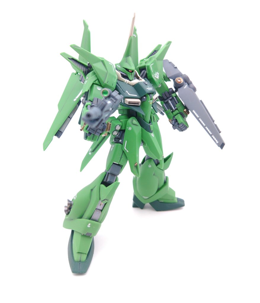 バウの量産型として、バウのグレミー機との差別化をするため、アクのあるパーツを地味化しています。グレミー機との変更点は以下です。 ・シールドのエンブレムを削る・胸部中央のマークを削る・各部にカラープラ板でディテールを追加カラープラ板では、追加装甲の他に整流板、エンブレム跡には、再度エンブレムを取り付けられそうなモールドを追加しています。頭や胸の黄色いパーツは形状を変えてしまうとバウではなくなってしまうので、おとなしめのシャンパンゴールドにしてワル目立ちを抑えています。また、胸部ダクトも薄いグレーにしています。