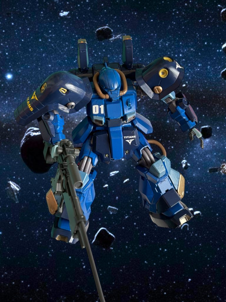 ケイン・マーキュリー少佐は、何が起こったか理解できなかった。正面のモニターには、自機の撃墜を知らせる表示が瞬いていた。 敵機を見失った後、一瞬、自身を射貫く稲妻のようなプレッシャーを感じた。感じた次の瞬間には、撃墜されていた。「くそ……っ!」 ケイン少佐は歯噛みしながら、シートの脇を拳で叩いた。 コクピットに設置した小さなモニターでは、航空宇宙祭の中継を受信している。揉み合うバーザムと、EFMPの白い機体の様子が映し出されていた。おそらく、ケインの撃墜をアラートで知ったのだろう。一瞬、バーザムに隙が生じた。その一瞬で、白い敵機が脇腹を蹴り、バーザムを引き離し、ライフルを叩き込んだ。同時に、見えない遠くから、もう一条の光線が刺さった。