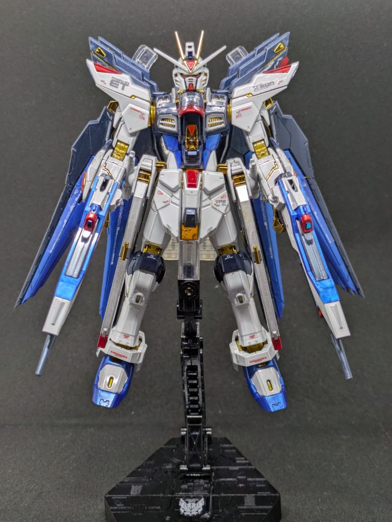 正面。フル装備だと背中の羽根がかなり重く、自立が難しいので早々に天空の翼付属のアクションベース2に取り付けました。なんとなく余っていたコンパスのシールを貼っています。デカールはキット付属のリアリスティックデカールです。シール保護のため全身に光沢トップコートを吹いています。おかげで全身ピカピカです。