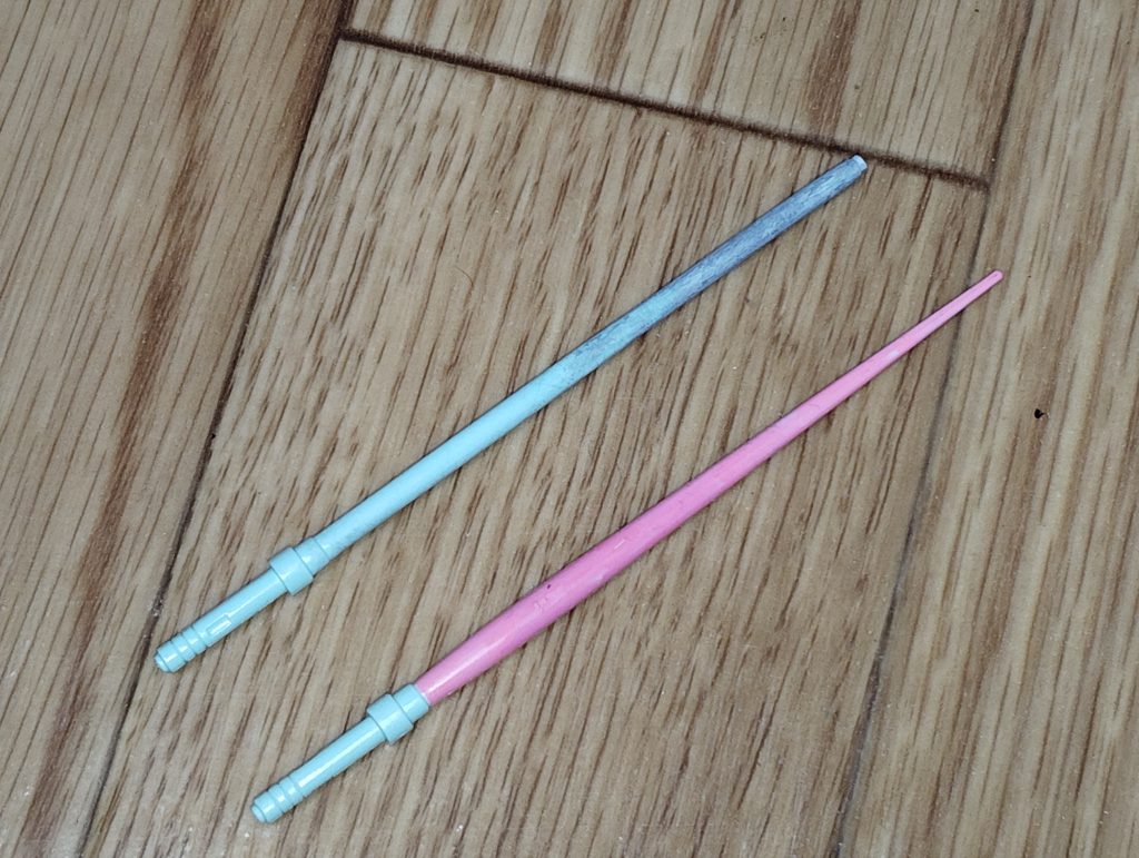 　ビームジャベリンの加工です。　ご覧の通り、ベースはHGUCジムの一体成型真っ白ビームサーベルです。　コチラの先端の方をパテで太らせてからサンドペーパーを巻き付けて削り、円柱状になるよう加工しました。　ここから均等な幅でスジボリを入れ、先端にビームジャベリンのエフェクトパーツを取り付けて完成です。