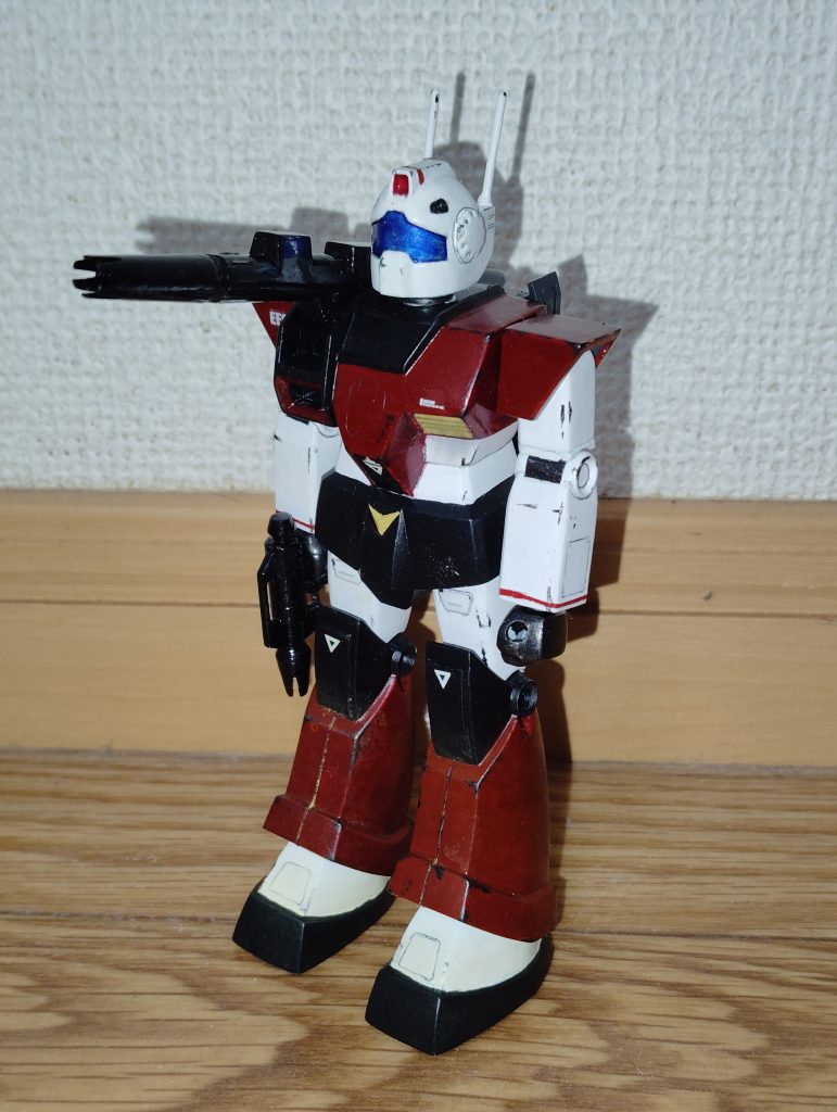 正面素立ちです。 使用したキットは、1/144旧キットMSVのジムキャノンです。 基本塗装はツヤ消し白、ツヤ消し黒、赤に黒を混ぜた暗めの赤です。 実はコチラの「赤」なのですが、以前投稿した「ジム(リアルタイプカラー)」と同じ色味にしたかったのですが、塗料ビンにストックしておいた色がどう見ても茶色だったので、塗装が乾いた上からクリアーレッドを塗り、仕上げにツヤ消しトップコートを吹いてあります。 苦労の甲斐あって、なんとかジムと並べても違和感のない色味にできたと思います。 関節などは黒鉄色、左胸のダクトと腰のV字マークはクリームイエローです。 ちなみに頭部カメラとバイザーは、下地を銀色で塗装した上から、それぞれクリアーレッドとクリアーブルーで塗ってあります。