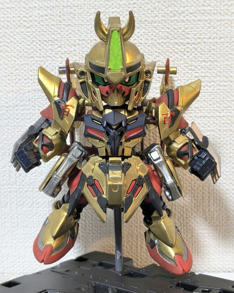 モチーフは半蔵と同様にワールドヒーローズの風魔。本人が派手なので自然とモチーフは百式になりました。当初演者を百式改とも考えたのですが、それだと百鬼丸になってしまうので、百式へ変更。頭頂部の角や額の縦長部分、ヒゲ？の元祖SDガンダム百式改のカミツキギミックモチーフなどは百式改モチーフの名残です。