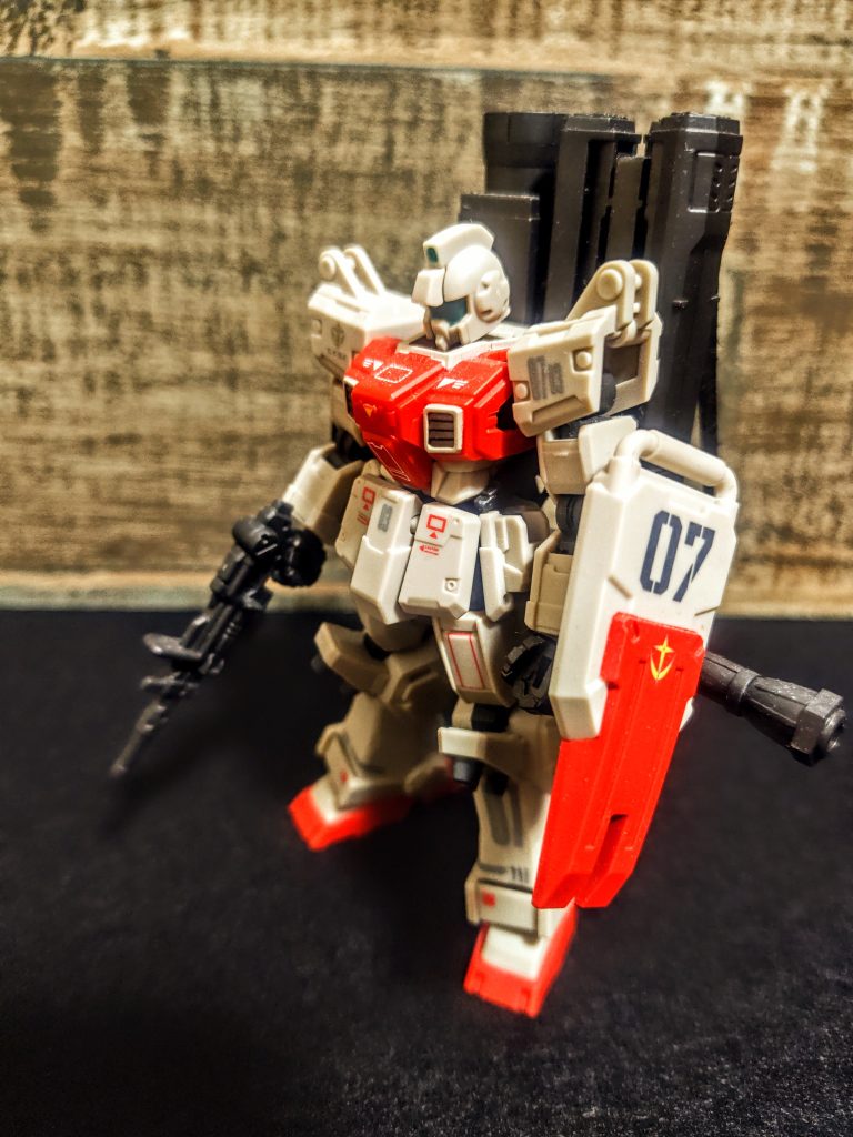 さて、今回のはちょっとだけ違うんです。ほら、ランチャーを背負って、腰にもバズーカをマウントして、それにそれに、「はい、同じです」量産型だからなにとぞ許してください。機体ナンバーは3にしました。前の2機種が素の陸戦型ジム、コンテナ搭載可能な陸戦型ジム、だったので、この子はとりあえず武器を背負いまくったヤンチャ仕様で。思えばバズーカって持たせるより、この横にマウントするのが一番しっくりきますよね。