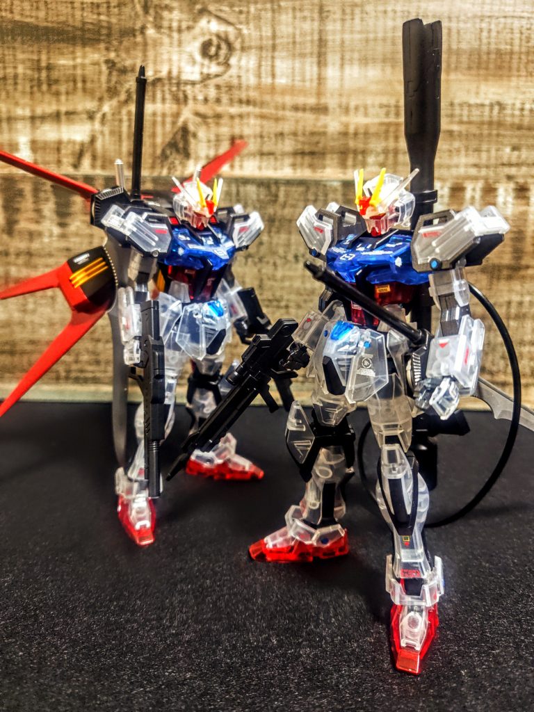 と言うわけで、クリアカラーの一番機と並べてみます。良いですねぇ、これが特殊なライトで照らすと無茶苦茶光るという（笑）、2体で光ってくれると本当盛り上がります。今回は本当ならクリアカラーの内側に金や銀で色々塗ったりしようかなと思っていたのに、気がつけばで出来上がってしまってました。シルエットがエールストライク版と違うので、今回はこれでいいかなと。いけませんねぇ、これをやるから、今度はちゃんと、とか何とか言ってまたストライクが増えちゃうんですよね。