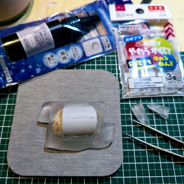 みなさんは、肩パーツのひとつが突如消えたりした経験はないでしょうか😨？神隠し、妖精の仕業としか思えないような、、、ウチの場合はちびっこさんがぶっちぎりで第1容疑者なんですが、ない物は仕方ないのでレシピにあったプラ板で作成しようと意気込みました✨、、、ムリでした(TдT)ﾁｰｰﾝｯ笑絶望的に寸法が合わず。。。ドム、MGザクの肩なども合わせて見てもまったく合わず。どうしよう、、タコザク断念がチラつき出した頃、「型枠」「レジン」などのワードが❗️そして、コレええやんをついに発見(ﾟ∀ﾟ)✨【おゆプラ型枠で肩パ複製✨】1.おゆプラ棒3本をコップに入れ熱湯を注ぎ3分待ちます🐱こちらがとんでもない性能で、お湯を掛ければ何度でも変形してやり直せる、昔のアニメのような超性能Σ(ﾟДﾟ)✨🐼2.グニャグニャになった1を珪藻土コースターの上で型枠①を成形。珪藻土が余分な水分を吸ってくれます✨3.肩パーツを2にずぶずぶとつっこみます😸そして両端に型枠同士をはめる為にカットします(写真4)その後、20分待ちます4.パーツ以外にメンタムを隅々に塗っていきます5.おゆプラ2本と、さっきカットした分をまたコップに入れて3分6.何度か珪藻土コースターの上でこねて余分な水分を取り、型枠①の上からかぶせて蓋となる型枠②を成形。カットした所にしっかり充填し、密閉していきます。20分固まるまで寝かせます🐱7.メンタムが効いてますのでスルッと取れますが割れないようにゆっくり型枠②と肩パーツを取り外します8.湯煎したレジンを型枠①の四隅から注ぎ入れていきます✨気泡は楊枝で潰れますが、行き渡らないところは何度か追加レジンで修正できますので気にせずやっちゃってください😸9.もりもりレジンを注いだら型枠②をしっかり押し込んで密閉します。この時カットした部分が効果を発揮、互いに噛み合ってズレない型枠となります✨10.ダイ◯ソーで300円、ネイルアート用のブラックライト照射機でまず2分、裏返して2分照射します✨11.カッチカチに固まります✨欠けているところはレジンをつけてまた型枠に戻して10の工程をもう一度12.3回ほどやったら欠けはなくなりました✨あとは鉄ヤスリでゴリゴリ削って出来上がり😸✨あまりにうまく行きましたのでヘッドも作ろうかと✨@まこアニキの動画を見て作成しました。アニキ、有り難うございます(TдT)（4枚目）