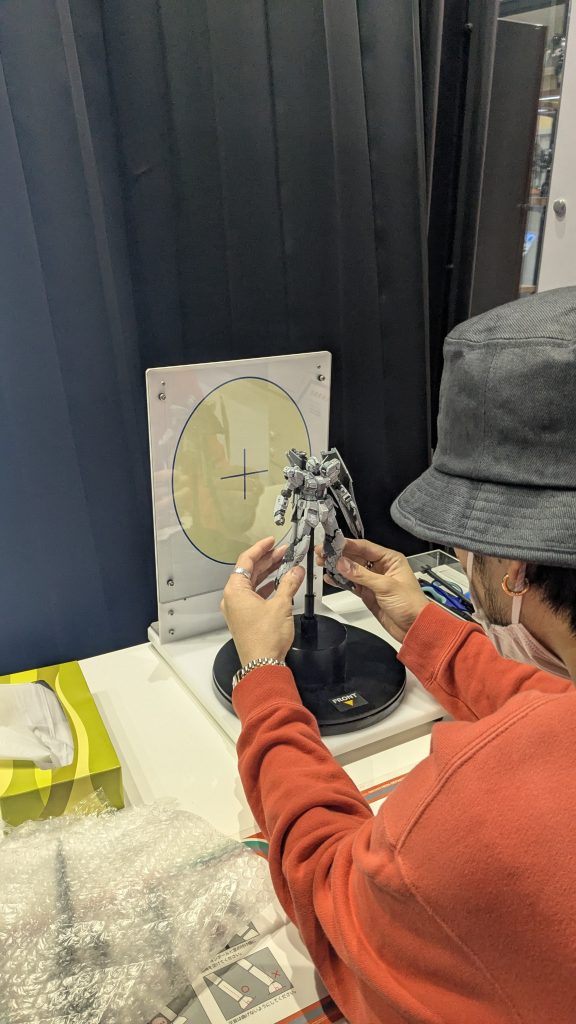 公式ウェブサイトより予約し、ガンダムベースへ来店！入口のスタッフさんに声をかけて入場。奥のスキャナーまで案内されます。着くなり早速準備開始。下準備は写真のスタッフさんがやってくれました！ありがとうございます。