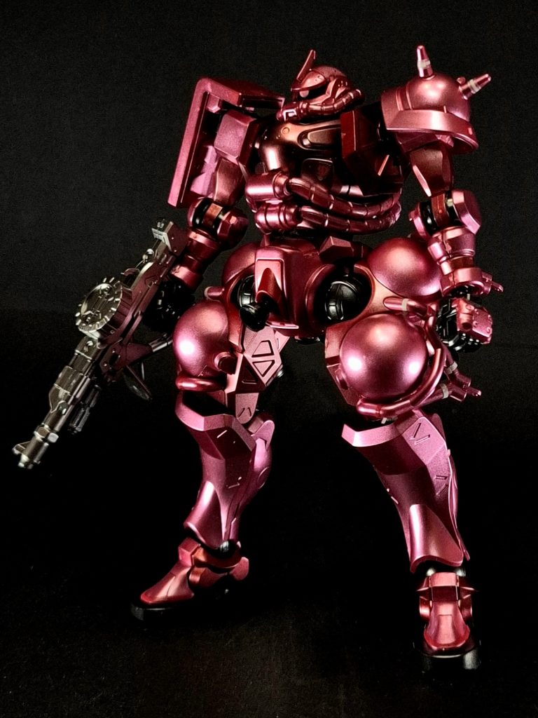 シールド右肩部に大型の複合装甲盾を備える[30]。漫画『MSV-R 虹霓のシン・マツナガ』第3巻ではこれについて、前面投影面積がもっとも少なくなる最適な攻撃姿勢（ザク・マシンガンを構えた宇宙での突撃姿勢）をとった場合、シールドの角が前にくる形となり、防御面積が最大になると同時に傾斜装甲を形成し、跳弾による被害の軽減を目的としているとされ、対艦攻撃の際に有効であったことが実証されていることが、エリオット・レム少佐（当時）をはじめとする登場人物の台詞で説明されている。