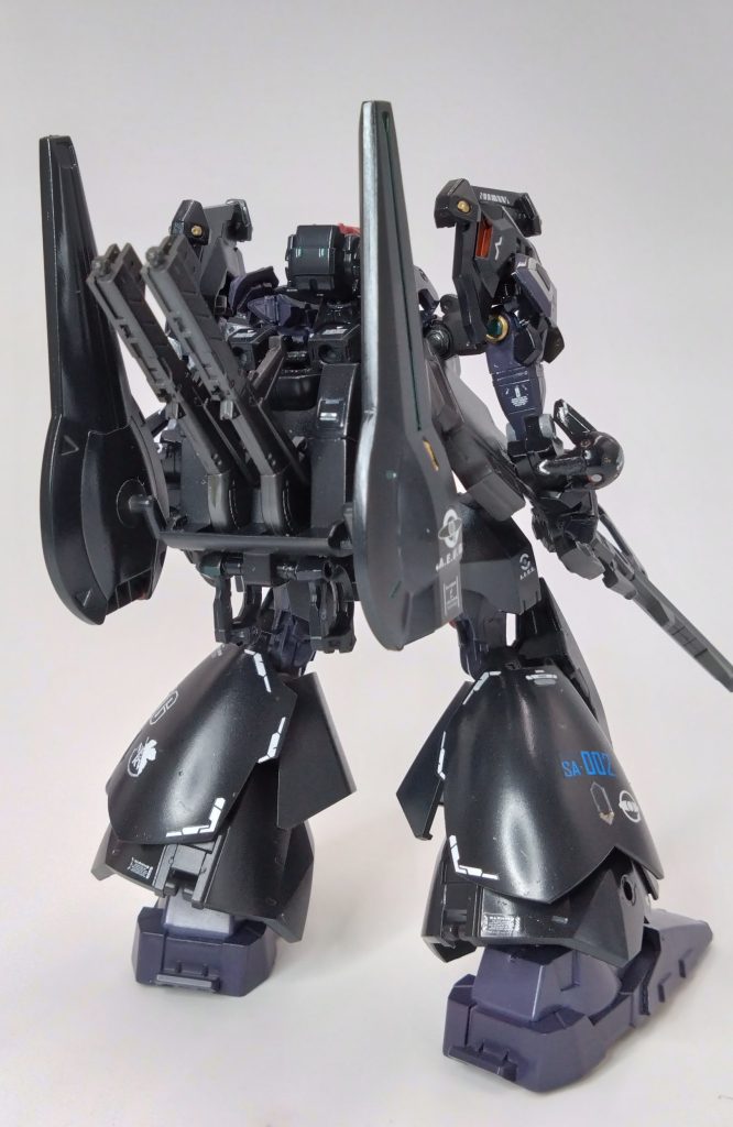 この機体はデルタと同じくエゥーゴ・ツィマッド社・NERVの共同開発プロジェクト『SEELE計画』で開発されたNT・一般用次期士官量産MSでジオンが開発した国産ガンダムｇMSシリーズジークアクスの素体をベースに連邦のMS研究機関サナリィの新型フレーム構造『ムーバブル・フレーム』を採用しNERVが開発した最新式ガンマ用サイコミュ搭載AIデバイス『MAKINAMI』搭載しているが一般用にも使用しやすいようにNT用デバイスもオミットすることも可能、主な特徴はツィマッド社の機体ドムのブロックモノアイ構造を採用・装甲材質は最新のガンダリウム合金を採用、背部にはビームピストル用にリチャージ機能を持つライトレーザーラック・推進用プロペラントタンク・スラスター・スタビライザー等の機能が内臓された複合モジュール『ランダム・バインダー』が装備されている。余談だがガンマにはもう一つ頭部の候補がありそれはジオニック社モノアイ型もありジオン軍用MSマラサイという次期量産型を生産する予定だったらしいがエゥーゴがジオニック・ツィマッドのお互いの関係築けるようにとマラサイ頭は中止となり、ジオンの次期量産はゲルググの発展機『ネモ』が採用した。