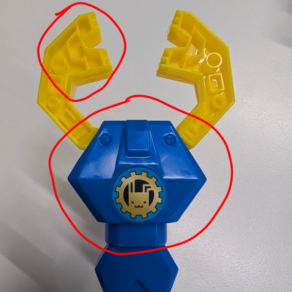 胴体の作成です、ロボットアームなるマジックハンの赤丸部分を適当にカットします。いい感じに貼り付けしたら完成、緑の部分は頭部作成時に切り取った指サックの切れ端です。次回は腕と腰を作成します。（1枚目）