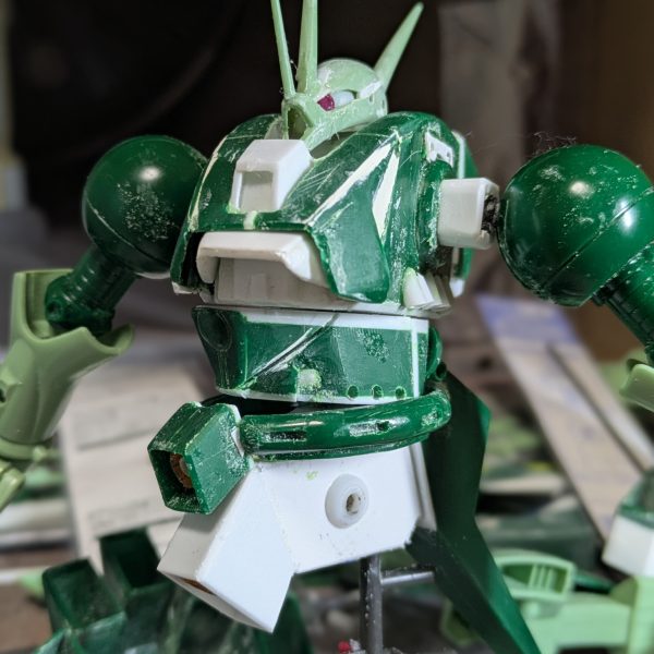 なかなか作業時間が取れずお待たせしております。胴体が形になってきたので投稿します。バックパックは、キットは設定と全く違ったので、ノズルパーツから自作して内部から出ているようにし、少し上にずれるように付けました。腰は、フロントのバーニアの角度が違ったので、下半分を自作して、下面にバーニアとスタンド用のポリキャップを仕込みました。腹は上部で回転、下面にボールジョイント可動を仕込んでいます。頭部のサイドアンテナは、ケーブルが設定と違ったので、代替パーツを検討するため外してありますか、モノアイは5ミリのジュエルシールを付けたので、表情が出たと思います。まだ手足が手つかずなので、これから腕の改造に進もうと思います。今回写真はありませんが、足がこのキット最大の難所かも知れません。それではご覧頂きありがとうございました。また切りの良いところまで完成したら投稿させていただきます。 (6枚目)