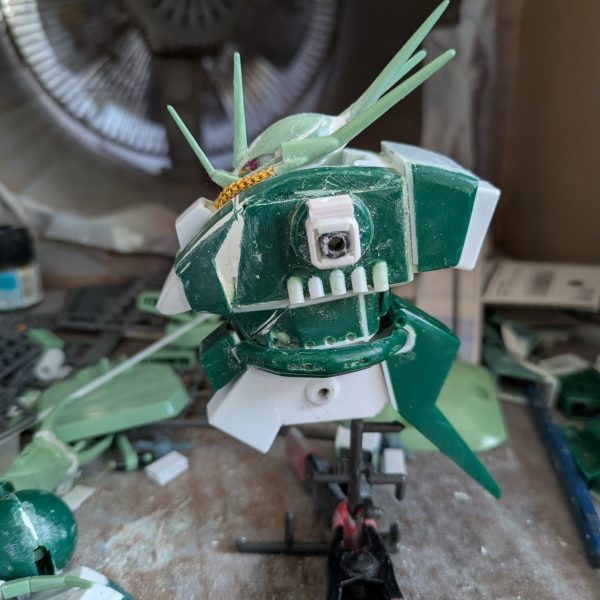 なんとか上半身は、完成できました。バックパックを上にずらした時、異常に腰が上がっていたのでよく見てみたら、元のデザインとキットの造形違いに気づき、首の後ろを4ミリ程下げる工作をしました。背面がかなり自然に見えるようになったと思います。腕は、上腕にロール軸を追加し、ケーブルっぽい部分をカットして、別パーツを付ける予定です。コードかスプリングかは検討中。肘は元のデザイン上、関節がないことに驚きました。検討した結果、キットのままです。手の爪は、100円ショップで3ミリのビーズを見つけたので、これでボールジョイント接続にしました。受けはセリアのプラ板が予想以上に柔らかいことを利用し、基部に3ミリの穴を空けて取り付けたところ、いい具合に渋みのある関節になりました。頭部のパイプは、100円ショップの手芸コーナーで見つけた、ヤーンという飾り紐で太さが2ミリと丁度良かったため、採用しました。肩は可動を諦め、3ミリ棒での接続にしてあります。腰回りは、胴体を幅詰めした分、調整が必要なのと、可動が必須なので後回しにして、これから脚部の改造を始めます。REのアレンジは参考にできないので、試行錯誤になりますが、元のデザインと可動をどうするか、これから検討します。正月明けには、塗装待ちくらいにまでは完成させたいと思いますので、温かく見守って下さい。それでは皆様良いお年を。（2枚目）