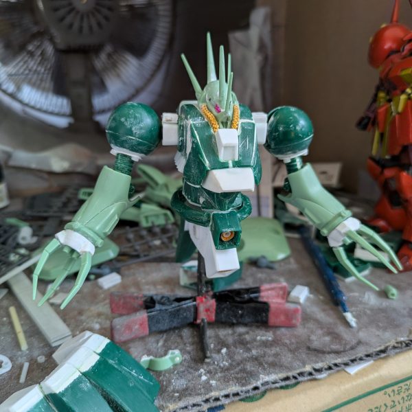 なんとか上半身は、完成できました。バックパックを上にずらした時、異常に腰が上がっていたのでよく見てみたら、元のデザインとキットの造形違いに気づき、首の後ろを4ミリ程下げる工作をしました。背面がかなり自然に見えるようになったと思います。腕は、上腕にロール軸を追加し、ケーブルっぽい部分をカットして、別パーツを付ける予定です。コードかスプリングかは検討中。肘は元のデザイン上、関節がないことに驚きました。検討した結果、キットのままです。手の爪は、100円ショップで3ミリのビーズを見つけたので、これでボールジョイント接続にしました。受けはセリアのプラ板が予想以上に柔らかいことを利用し、基部に3ミリの穴を空けて取り付けたところ、いい具合に渋みのある関節になりました。頭部のパイプは、100円ショップの手芸コーナーで見つけた、ヤーンという飾り紐で太さが2ミリと丁度良かったため、採用しました。肩は可動を諦め、3ミリ棒での接続にしてあります。腰回りは、胴体を幅詰めした分、調整が必要なのと、可動が必須なので後回しにして、これから脚部の改造を始めます。REのアレンジは参考にできないので、試行錯誤になりますが、元のデザインと可動をどうするか、これから検討します。正月明けには、塗装待ちくらいにまでは完成させたいと思いますので、温かく見守って下さい。それでは皆様良いお年を。（4枚目）