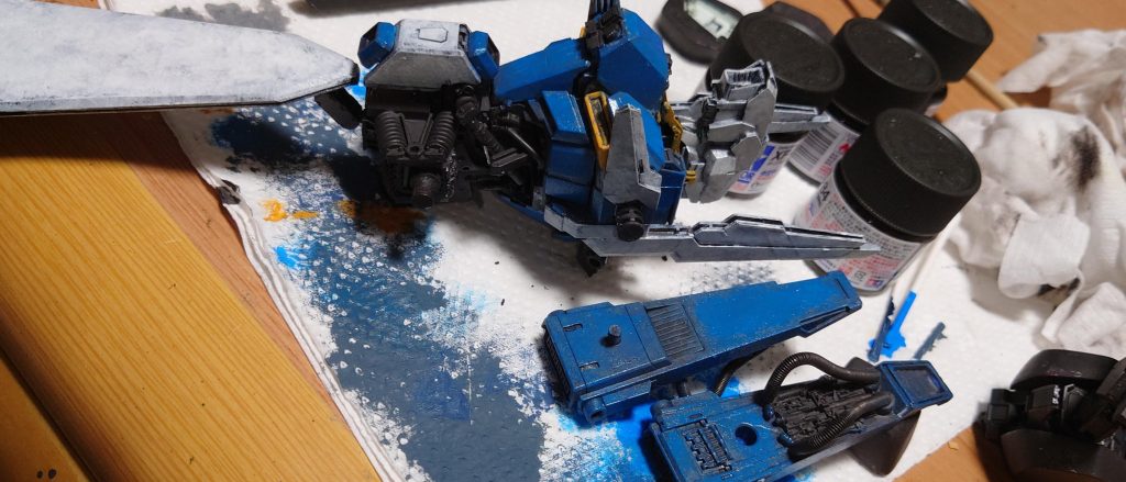 塗装はオール筆塗り。昨今のトレンドと真逆を行く形で塗面を綺麗に仕上げるどころか、筆ムラを敢えて作るようにガシガシ塗ってます。溶きパテを塗布してから、下地にはタミヤアクリルのダークアイアン（ 履帯色）。そのままメカ色に使ってます。白と青は水性ホビーカラー、黄色部分はシタデル。影になる部分に下地が残るように、希釈せずドライブラシの要領で筆を乱雑に塗りつけ。塗面の凸凹を活かしてウェザリングマスターを何色も使ってベシャベシャに汚してます。展示会に間に合わせる為に後半は急いで製作したので反省点も残りますが、手元にデカいスーパーZZがある満足感を得られたので良しとしてます（ 気に入らない部分は後から加工すればOKのマインド😂）閲覧ありがとうございました🙇