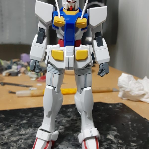 下半身の工作が終わった0ガンダム(正確にはスネ横の合わせ目消しがまだだけど)。バランス確認のため、上半身を乗せてみた状態がコレ。 ボリュームアップした脚部とのバランスをとるため、腰のセンターアーマーを大型化。横に1.2mm、縦に0.5mm延長。それに合わせて天面の赤いブロックをプラ板で覆った結果、真っ白になりました(笑)。腰回りのバンダイエッジも削り落としてます。地味に好きな作業。 もともと足が長いので、股下を基準に上下比を測ったらちょうど4:5くらい。腹部が詰まって見えるので、天面で1.5mm延長しようと準備中。そうすると、腕も1mmほど伸ばす必要があるかも。 頭も合わせ目にプラ板を貼ってちょっと大型化しようかなぁ。あと、据わりが悪すぎる首!すぐ回転したりアルファベットのZみたいな形に折れ曲がったりするので渋みの調整が必要。 ドミノ式に改造箇所が増えていっている気もしますが、やはりプロポーション変更は楽しいです。(2枚目)