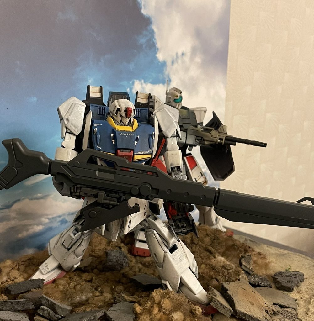 バスターランチャーはMGサザビーからの援用です。かなり大きいです。右手でヒンジを握りつつ、左の平手で支えるイメージです。背面ウェーブライダーの重量に鑑み大型の武器を携帯させることで前へ重心をずらして全体のバランスを取りました。写真では見えませんが右手が握るヒンジは陸戦型ガンダムの80mmキャノンのものを援用しています。近藤氏のイラストを参考に肩の位置を上へずらしています。