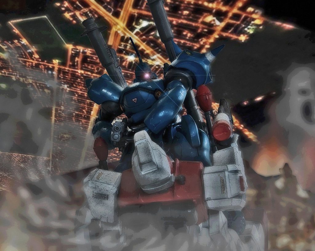 「…くそっ、奴は!?」煙が薄まり、小隊長が目を開けた次の瞬間、硝煙の匂いが香る銃口が自分に向けられていた。そして蒼いMSは片脚でジムを押さえつけると、モノアイを光らせ睨みを利かせる。その仕草は妙に人間ぽく、中のパイロットの人格を映し出しているようだった。(…俺はここまでなのか…？)なんとか抵抗しようとビームガンを向けるが、先に火を吹いたのは敵機の銃火器だった。ショットガンのフォアエンドをスライドさせるとコクピット部位を撃ち抜いた。至近距離で撃たれた破壊力は凄まじく、ジムの装甲を貫通させると動脈を傷つけたかのように潤滑油が噴き出す。