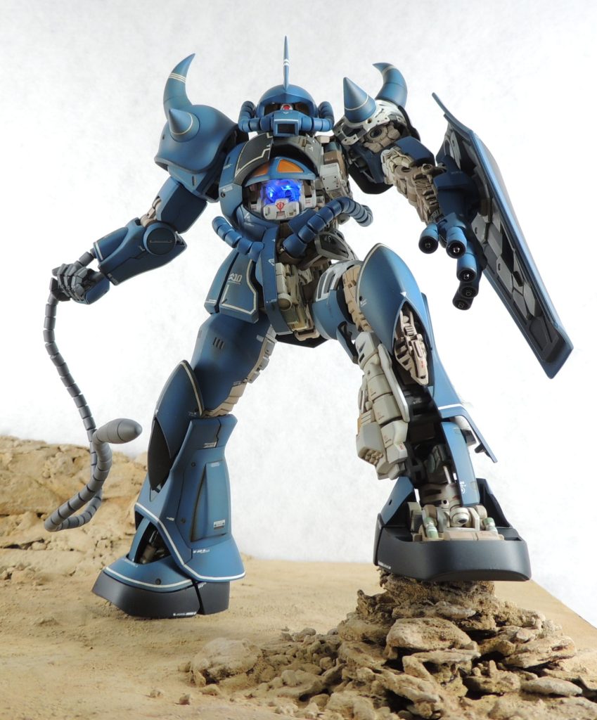 ■外装の塗装広い面のエアブラシ塗装と極細の面相筆による細部の塗り分けはラッカー系塗料を用い、スミ入れとウォッシングにはエナメル系塗料を使用しました。まず、メカサフヘヴィにより外側と内側の両面に下地塗装を行った後、スパイク・腰部アーマー・脚部にホワイトを部分塗装し、0.4mm幅と0.7mm幅のマスキングテープを使い分けてラインとなる部分にマスキングを行いました。乾燥後、メカサフヘヴィをライン上に吹いて下地の色を均一化した後、全体を「東雲ブルー」で塗装しています。ベタ塗りは避け、各面の下側には濃いグレーが残るようにエアブラシの吹き付け加減をコントロールしました。なお、外装がより立体的に見えるように、東雲ブルーにホワイトを足して各パーツの上面にハイライトを吹き付けています。渋めの色彩による単色塗装により、ミリタリーテイストが高まったと思います。