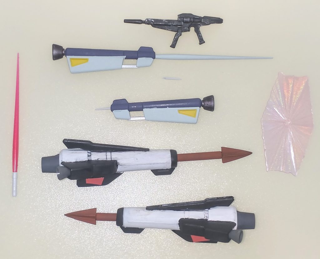 武装類。ビームライフルは初代HGガンダムアストレイのライフルをベースに各ジャンク品で製作したものを用意しました。ジャベリンユニットはバックパックの接続をアーム式に変更、砲身に各ガンプラのサーベル基部を組み込みショットランサーの展開ギミックを差し替えで再現しました。追加武装として「 V-MSV」にて設定された対艦用ジャベリンの装備メガスピアを用意しました。1/100Gキャノンマグナに付属するGキャノンのマシンキャノンをベースにプラ材・ジャンク品で設定画から若干アレンジして再現しました。ランスも取り出せるようにしています。
