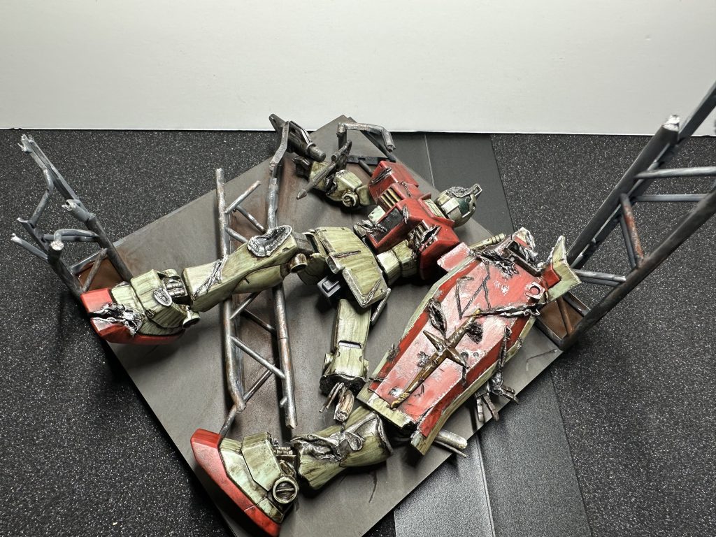 HGジムをジオラマ風に作成。形成色仕上げてつや消しコートを吹きウェザリング。ホットナイフでの傷入れや、適当な電気コードを使った内部メカの露出を少しだけ行なっています。初挑戦の加工だったので甘いところも多々あり。