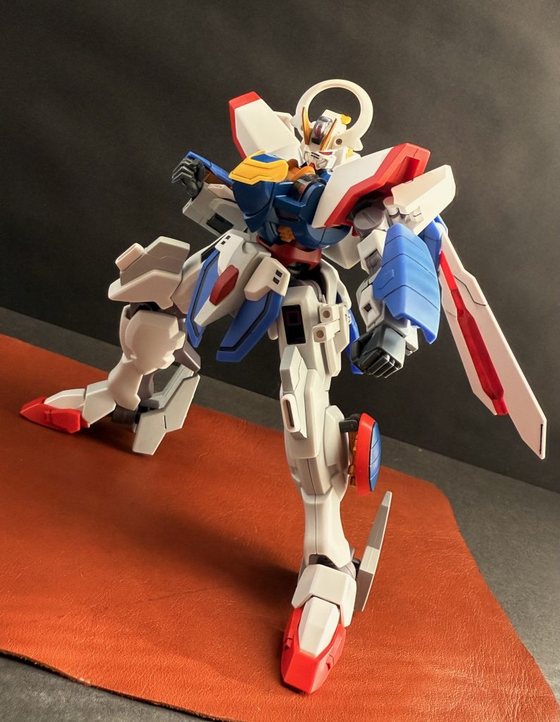 　…ガンダム？…ッガンダムだと！思わずリーダーは叫んでしまう。見れば、他の仲間達も同じように動揺しているようだ。　この動揺は、今、土門と対峙している不良グループだけのものでは無かった。この決闘を観ている生徒、教員達にも同じように拡がっている。しかし、そんな周りの動揺をよそに、土門の乗った「シャイニングガンダム」は、まるで人間のように、いや、人間そのものの動きで滑らかにその手足を動かし、KARATEを彷彿させる様に拳を、蹴りを繰り出し、「型」を極める。　その様子に、不良グループ、生徒や教員誰もが見惚れていた。しかし、次に彼らが目にしたものに再び驚嘆する。シャイニングガンダムのコクピットに立つ土門の姿がスクリーンに大写しになったのだ。コクピットの中で、シェルユニットの輝きを放つ全身タイツを着た土門がビシリ、ビシリと拳を、蹴りを繰り出すと、それと全く同じ動きをシャイニングガンダムがするのだ。…誰もが、その様子に呆気に取られている。　…さて、ここで少しお時間をいただいてもよろしいでしょうか？（唐突に赤いスーツに眼帯の男が現れる）…私の名前はMr.ストーカー。彼の闘いを追う者です。（男はスツールに腰掛けると足を組み話し始める）「もし、皆様方がよろしければ、現在、この世界のGUND技術がどの様になっているのか、少しご説明させて頂きましょう。…そもそも数十年前です。このアスティカシア学園でとある会社が設立されました。「株式会社ガンダム」。…当時、世界に、人々に忌み嫌われていたGUND技術を医療技術へと転換させる事を目的とした会社です。…軍事から医療へと転換されたGUND技術は、とりあえずの成功を納めました。そして今となっては、疾患を持つ人、体に不自由を持つ人々に受け入れられ、彼らにとってなくてはならないものになっていったのです。…そう、GUND医療は、世界に、人々に認められたのです。……しかし、しかしです。そんな中、奴等、そう、軍がやりやがったのです。軍事から医療へと転化したGUND技術を、再び軍事へと転換したのです。それも医療技術のままで。人からGUNDへ、たとえるならば、義肢をパーメットリンクし動かす様に、人間の動きをそのままMSに伝える新たな操縦システムをつくったのです。…「パーメットトレースシステム」。パイロットは、全身を包むシェルユニットが織り込まれたパーメットスーツを着用することにより、MSとリンク、しかも、基盤となっているのは医療としてのGUND技術の為、パーメットリンク時の副作用、負担は、ある一定の状況を除いてほとんどありません。…なんと素晴らしい操縦システムを作り出したことか。…ですが、問題がひとつあったのです。パイロットの動きがそのままMSの動きになる。ということはパイロット自身が「強く」なくてはならなかったのです。軍はそれに気付きませんでした。シートに座り、レバーやペダルでMSを操縦するエースパイロットが、生身、自身の肉体で闘っても強いとはかぎらなかったのです。…今この時代、武術の達人などそうそう居るわけがないのですから」　男はやれやれとかぶりを振ると、スツールから立ち上がる。…だが顔をあげ、着ていたジャケットをバサリと脱ぎ捨て、眼帯をむしり取る（両目はきちんと有る）と両の拳を高々と上げ言う。「ですが、…ですが！居たのです。彼こそが、流派東方無敗の継承者。最強の証、キングオブハートの称号を継ぐ者！…その名は、克州土門！彼が一体どんなファイトの嵐を吹き荒らすのか！…さあ、皆さん。お待たせしました！ガンドアームファイト！…レディィ…ゴォォッ！！」