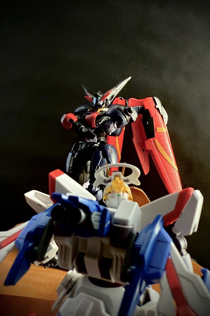 「フフフ…。腕を上げたな。土門」「…ッ！…その声は、師匠ッ！」　学園の長期の休みを利用し、土門は一人、地球に修行にきていたのだ。その頃、地球ではある事件が発生していた。AIによって稼動する様々な機械がウイルスによって暴走する事件が多発しているのだ。それは、近年の人口減少も相成りAIで運用される様になったMSも例外では無い。土門は、修行と称し、暴走し破壊するしか無くなってしまったMSを倒してまわっていたのだ。土門の周りには、倒したデスヴォルヴァが山と積み上がっている。　…さて、ここで再び出しゃばる事をお許しいただけるでしょうか。（やはり現れる、眼帯に赤いスーツの男）「もし…、よろしければ、この時地球で何が起きているのか、そして、土門の足元に山と積み上がっている機体について、ご説明させていただいてもよろしいでしょうか。…まずは、土門の足元のMSから、…とはいえ、コレをMSといってもよろしいのでしょうか？と、いうのも、土門が学園に転入し、決闘に勝利したのと時を同じくして、地球ではある事件が急増しました。それは、AIで制御されたあらゆる機械という機械がウイルスによって暴走し、人を、人が造った物を破壊し始めたのです。…何と痛ましい事でしょう。AI制御の機械、それは人口減少に伴いパイロットの少なくなったMSも例外ではありません。…特に、ウイルスはパーメットニウム。シェルユニットを始めとするGUND技術に対し、多く作用しました。…多くの人々がGUND技術の恩恵にあやかっているこの時にです。ウイルスによって暴走した機械は、そのウイルスの特徴、自己進化、自己再生、自己増殖。この三つの恐ろしい能力によって人々に害を成し始めました。こうして、新たな人類の敵となったウイルスに、政府と軍はこう名付けました。『DP細胞（デビルパーメットさいぼう）』と…。シェルユニットを好むそのウイルスは、過去の事件で運用され、軍によって厳重に管理、保管されていたMS、『ガンヴォルヴァ』に目をつけました。…こうして、ガンヴォルヴァはDP細胞によって自ら進化し、自己修復、増殖機能を持った恐ろしいMS。『デスヴォルヴァ』として、地球上あらゆる場所に現れると、まるで人を人とも思わない破壊の限りを尽くし始めたのです。ですが、土門は、それを放っておく事など、いや、見て見ぬ振りなど出来ませんでした。…自らを高める為、DP細胞に襲われた人々を助ける為。土門は闘い続けるのです。…そして、そんな土門の前に思いがけない人物が現れたのです。…はたして、この邂逅は土門にとってどの様な結果を招くのでしょうか？…それでは皆さん！お待たせしました。ガンドアームファイトッ！レディィ…ゴォォー！」「フフフ、久しいな、土門よ」　懐かしい声に土門は顔を上げる。そこには陽の光を浴びて、鈍く輝く漆黒の機体。声はその機体から聞こえてくる。師匠、お会いしとうございました。そう言う土門の元に黒い機体は滑る様に近付いて来ると、土門の、シャイニングガンダムの横に肩を並べる様に立ち、構えると言う。「積もる話はあるだろうが…、先ずは、こ奴らを片付けてからだ。土門」　そう言う師の声に土門は、グルリと周りを見回す。そこには、先ほど倒した以上のデスヴォルヴァがカメラアイを不気味に光らせズラリと土門たちを囲んでいるのだ。　並び立つ、師の黒い機体に土門は問う、「師匠、その機体は…」「…そうか、お前にはまだ見せていなかったな。Master GUND-ARM。『マスターガンダム』…。これがワシのガンダムよ！」　そう言って、全方位から（地中からもだ！）襲い来るデスヴォルヴァをあしらう様に倒すマスターガンダム。「…数が多いな。…ならば、久々にアレをやるか土門よ！」「…ハイッ！師匠！」　二機のガンダムはピタリと動きを揃え構えると踊るようにデスヴォルヴァを薙ぎ倒していく。「流派！」「東方無敗はッ！」「「王者の風よッ！！」」「全新」「系裂」「「天破俠乱！！」」「「見よ！東方は赤く燃えているッ！！」」　