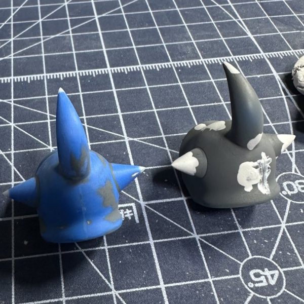 HGグフをキャンディ塗装で製作中。現在はパーツの乾燥待ちです。 合わせ目を消すために太ももと腕関節のあとハメ加工を施し、合わせ目消し→捨てサフ→パテ盛りと磨き直しを行い改めて塗装。肩アーマーのトゲ鋭利化も実施しています。メカサフ→光沢ブラックの塗装を全パーツに。明るいブルーパーツにはメタリックブルー→クリアブルーのキャンディ、暗いブルーにはメタリックブラック→クリアブルーのキャンディ。関節他黒系のパーツにはメタリックブラック→クリアブラック。モノアイレールだけは光沢ブラックで終え、オレンジのクリアパーツはそのまま使用する事に。（3枚目）