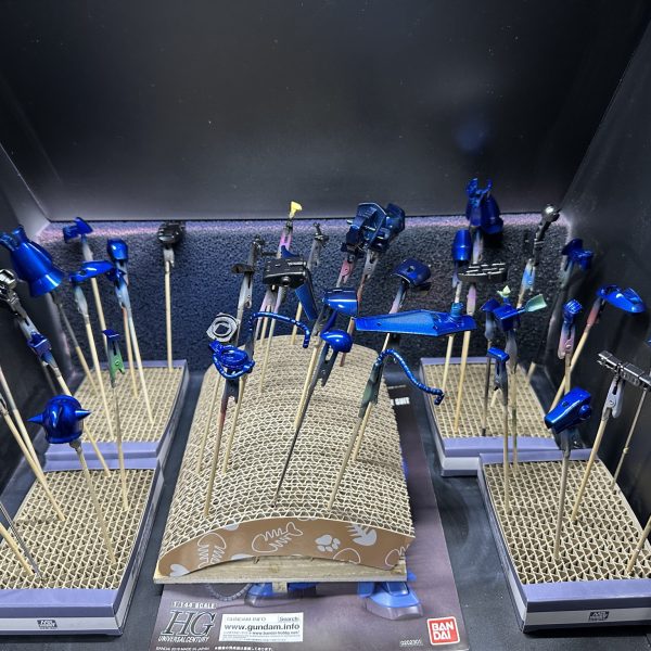 HGグフをキャンディ塗装で製作中。現在はパーツの乾燥待ちです。 合わせ目を消すために太ももと腕関節のあとハメ加工を施し、合わせ目消し→捨てサフ→パテ盛りと磨き直しを行い改めて塗装。肩アーマーのトゲ鋭利化も実施しています。メカサフ→光沢ブラックの塗装を全パーツに。明るいブルーパーツにはメタリックブルー→クリアブルーのキャンディ、暗いブルーにはメタリックブラック→クリアブルーのキャンディ。関節他黒系のパーツにはメタリックブラック→クリアブラック。モノアイレールだけは光沢ブラックで終え、オレンジのクリアパーツはそのまま使用する事に。（7枚目）