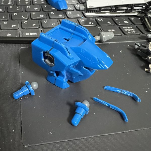 MGや作画では後ろ襟は無いようなのでカット。塗装の事を考えて襟の一部を切り離し。肩の軸はボールデンの中に置き換え、元の軸も腕との接続に使うので再利用。胸部中央はスカスカなのでパーツを埋め込み。(HGエクシアの足首装甲とプラ棒)（2枚目）