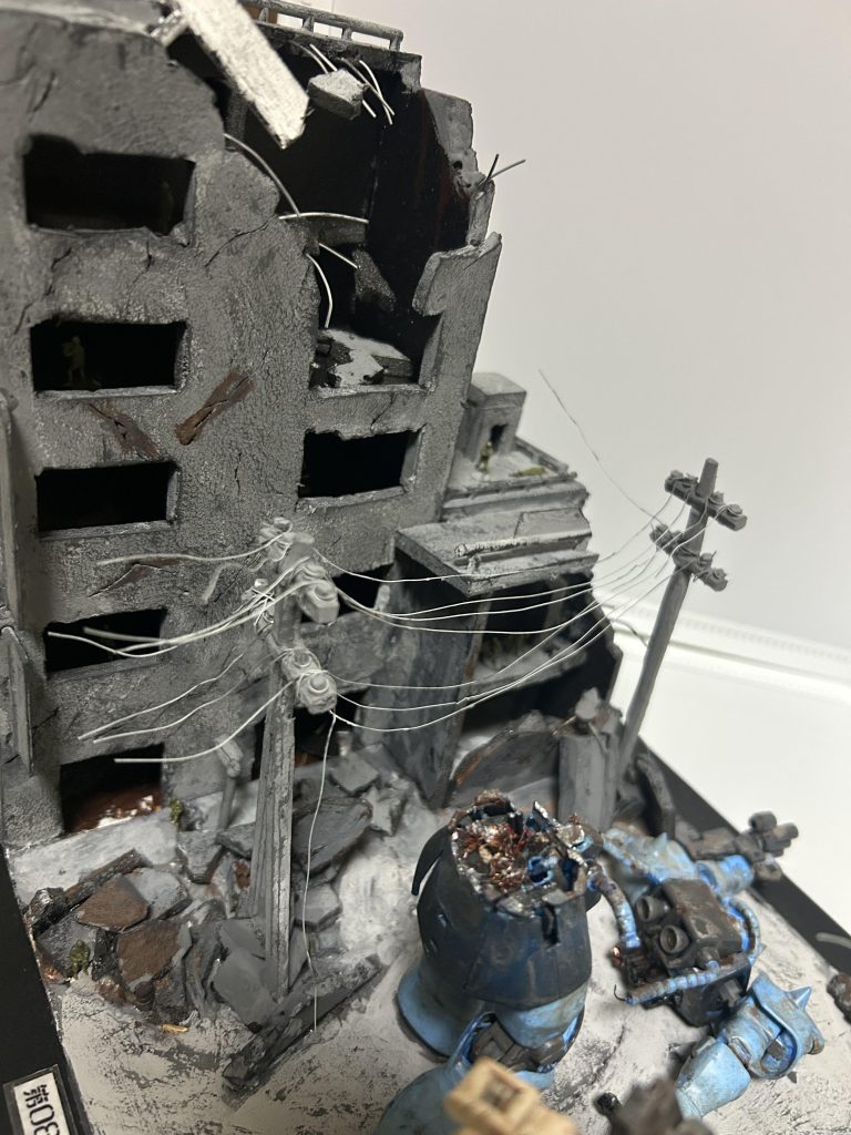 これはビルの前を撮っていますが、建物の看板などもプラモデルのランナーを使っています！ちなみにエアリアルのランナーです笑！いやそこはez8とかじゃないんかーい！とつっこみたくなるのはわかりますが…。バレなきゃいいんですよ…バレなければねぇ！(悪)あとよーく見れば電柱も作っています。