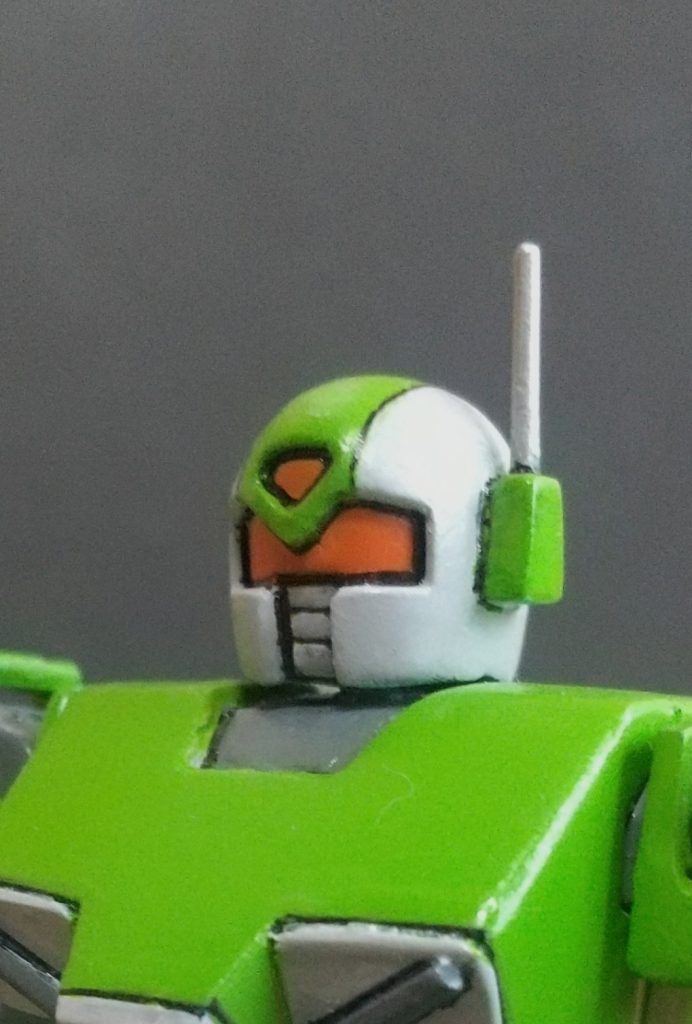 まず頭頂部のちょんまげ(メインカメラだかセンサー機能だか)の部分をカット。ゴーグルに区切りを設けて、区切りの上部分にちょんまげが埋め込まれてるという設定にします。その際区切りの下部分の機能が縮小されるので、側頭部にアンテナを設けてそいつが補助的役割を果たすので性能低下することなく軽量化している…というテイでお願いしますwそれと口のとこもカット、そのままだとただの空洞なのでプラ版でフタをします