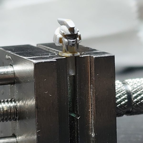 ガンダムアーティファクト第1弾のhi-νガンダムの頭部改修完成【頭部2】①アンテナブレードの小さいほうもプラ板で切り出し、持ち手のプラ板に接着してヤスリで整える②頭部のバルカンディテールを追加。エポパテを棒状にしたものを接着。③頭部は3パーツ構成にしました。今までの改修はフェイス部分を別パーツ化して、2パーツ構成でした。しかし、最後にフェイス部分をスライドしてはめ込む時にうまく入らない、ラピーテープの目が取れたりと苦戦するのでアーティファクトのガンダム系のひさし＆角で、上記の問題を解決することにしました。口も別パーツ化することでシャープ化、塗り分けがきちんとできる利点を得れると思います。問題点は、小さすぎてピンセットではじいて紛失しまくりです(-_-;)④原型と比較　1弾のガンダム系はしょうがないよね。最新弾のνガンダムは改修の必要ない出来。バンダイの技術はすげーや(>_<)あとは、塗装してスミイレがきれいに出来ること願うまでです(>_<)（3枚目）