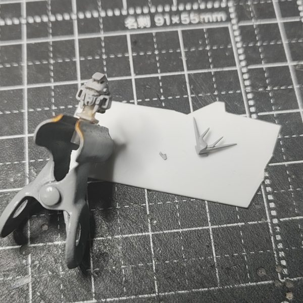 ガンダムアーティファクト第1弾のhi-νガンダムの頭部改修完成【頭部2】①アンテナブレードの小さいほうもプラ板で切り出し、持ち手のプラ板に接着してヤスリで整える②頭部のバルカンディテールを追加。エポパテを棒状にしたものを接着。③頭部は3パーツ構成にしました。今までの改修はフェイス部分を別パーツ化して、2パーツ構成でした。しかし、最後にフェイス部分をスライドしてはめ込む時にうまく入らない、ラピーテープの目が取れたりと苦戦するのでアーティファクトのガンダム系のひさし＆角で、上記の問題を解決することにしました。口も別パーツ化することでシャープ化、塗り分けがきちんとできる利点を得れると思います。問題点は、小さすぎてピンセットではじいて紛失しまくりです(-_-;)④原型と比較　1弾のガンダム系はしょうがないよね。最新弾のνガンダムは改修の必要ない出来。バンダイの技術はすげーや(>_<)あとは、塗装してスミイレがきれいに出来ること願うまでです(>_<)（4枚目）